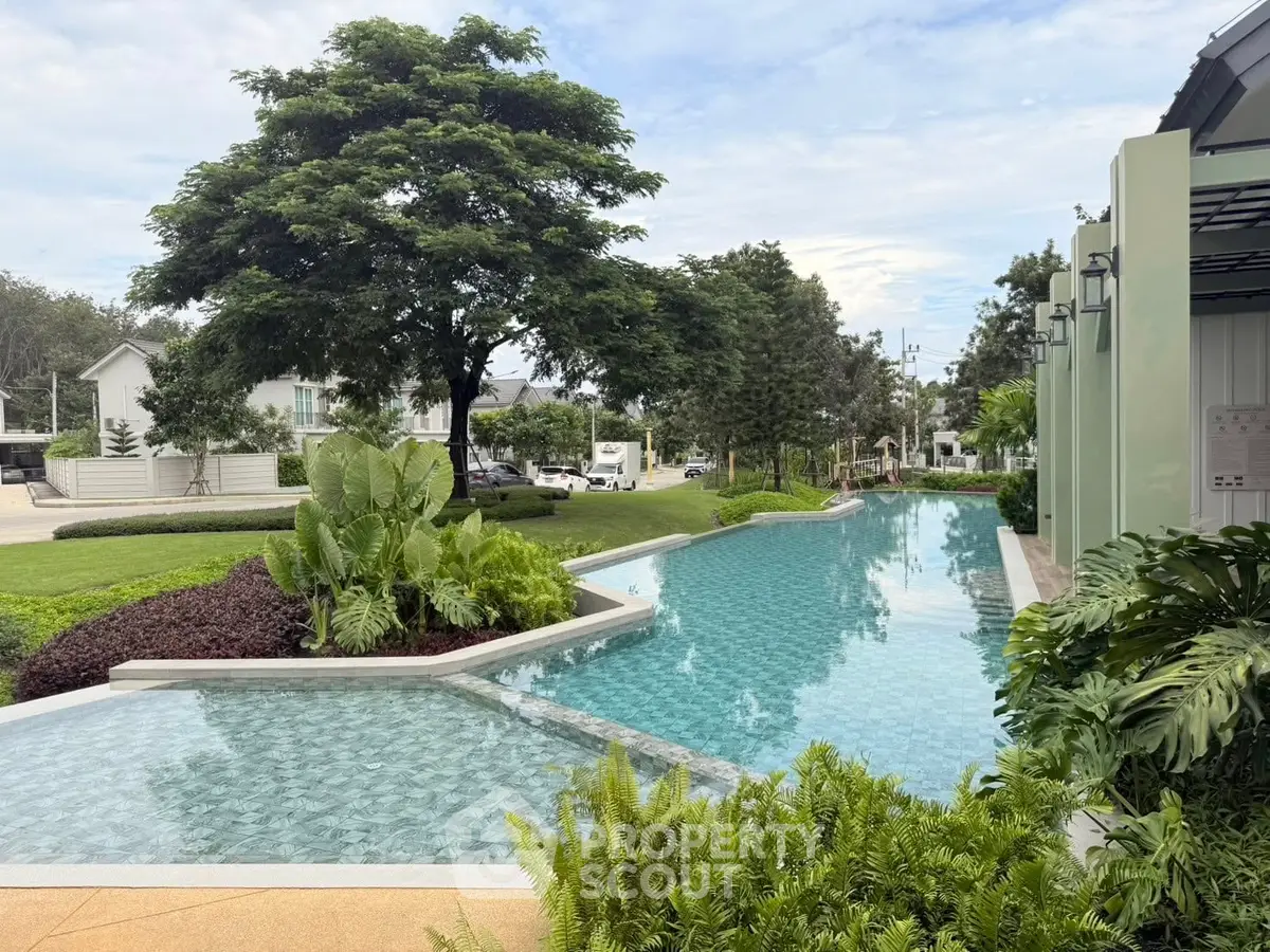 Luxurious outdoor pool with lush greenery and serene surroundings in a modern residential area.
