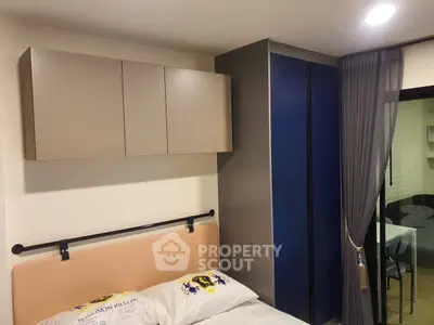 Modern bedroom with sleek storage and sliding glass door to study area.