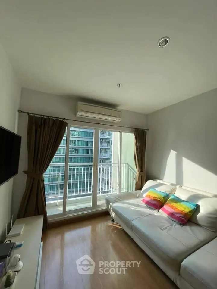 Bright living room with modern decor and large windows offering city views.