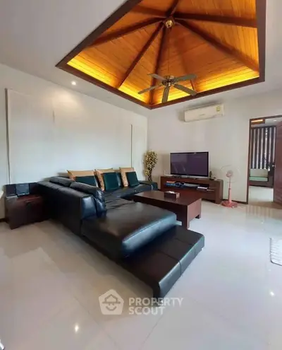 Luxurious living room with modern leather sofa and elegant wooden ceiling design.