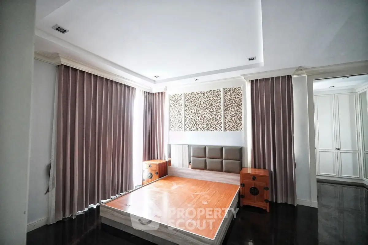 Spacious bedroom with elegant design and large windows for natural light.