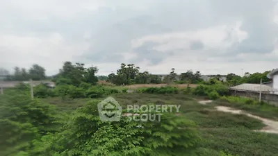 Expansive green landscape with lush vegetation and cloudy sky, ideal for development.