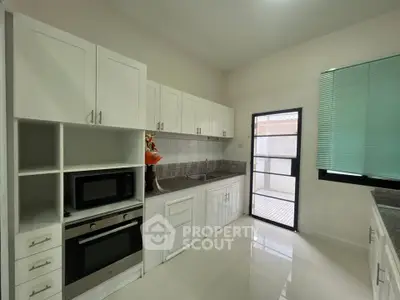 Modern kitchen with sleek white cabinets and built-in appliances