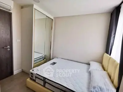 Modern bedroom with mirrored wardrobe and cozy bed in bright apartment.