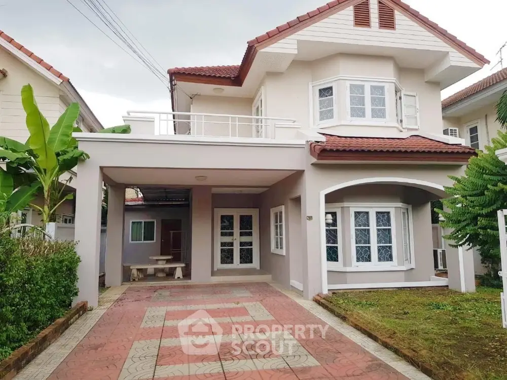 Charming two-story house with red roof and spacious driveway in a serene neighborhood.