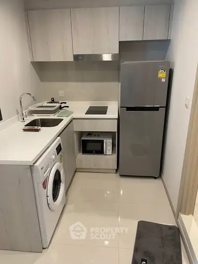 Modern compact kitchen with sleek appliances and minimalist design