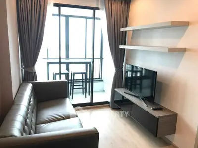 Modern living room with sleek furniture and balcony view in a stylish apartment.