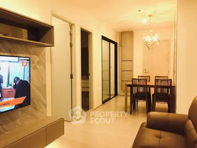 Modern living room with dining area and stylish lighting in a cozy apartment.