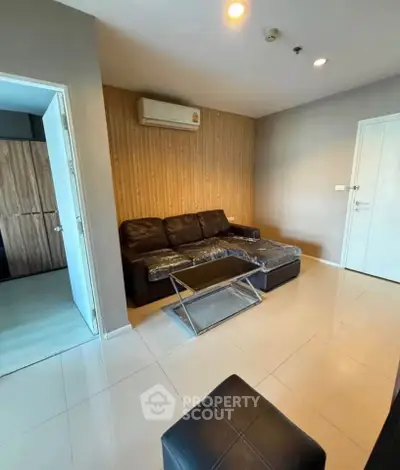 Modern living room with sleek leather sofa and air conditioning in a stylish apartment.