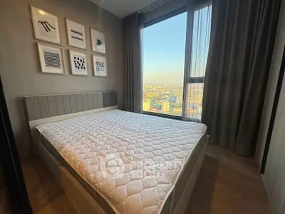 Modern bedroom with city view, featuring stylish decor and large window for natural light.
