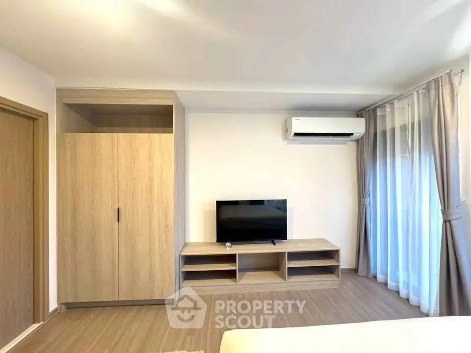 Modern living room with sleek wooden furniture and air conditioning, perfect for comfortable living.