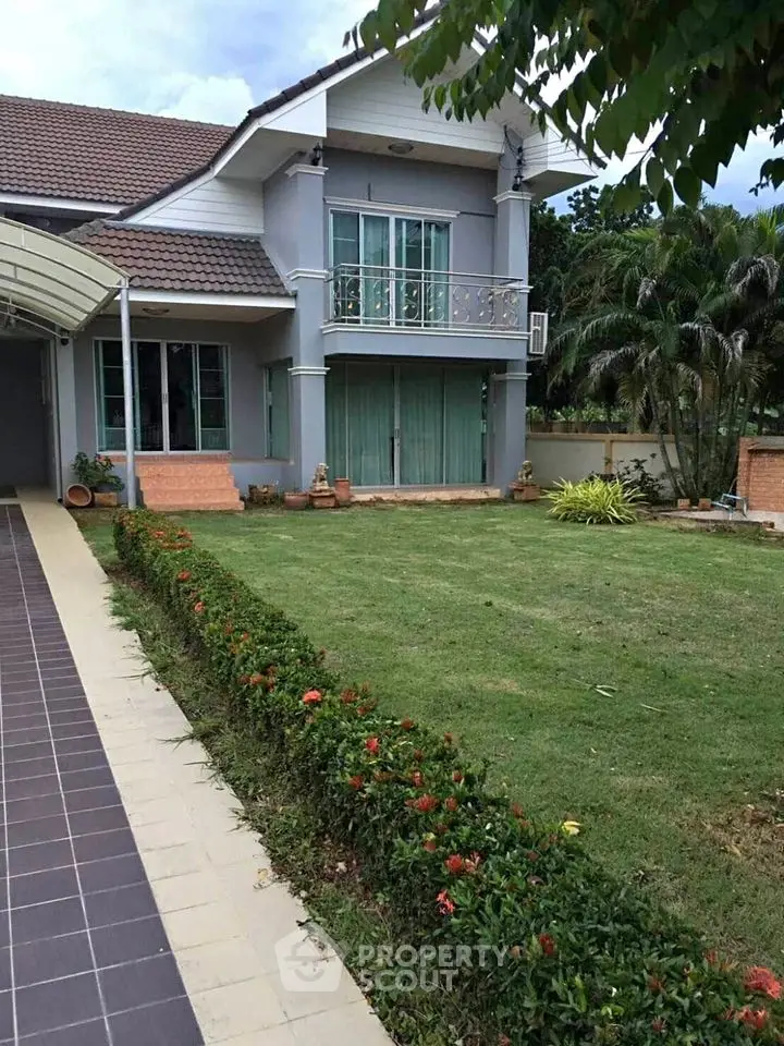 Charming two-story house with lush garden and balcony in serene neighborhood.