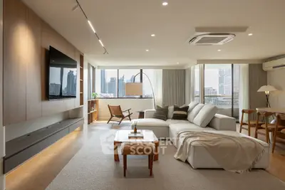 Spacious modern living room with city view, elegant furniture, and natural lighting.