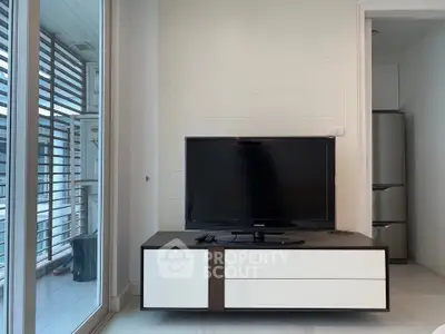 Modern living room with sleek TV stand and large window for natural light.