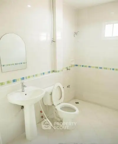 Bright and clean bathroom with modern fixtures and tiled walls.