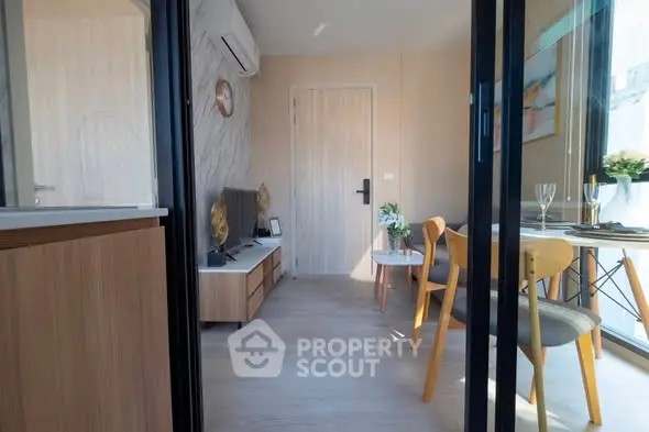 Modern living room with stylish decor and dining area in a bright apartment.