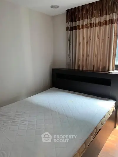 Cozy bedroom with natural light and elegant curtains, perfect for restful nights.