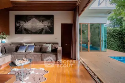Luxurious living room with pool view, wooden flooring, and elegant decor in modern home.