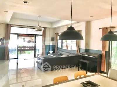 Spacious living room with modern lighting and large windows for natural light.
