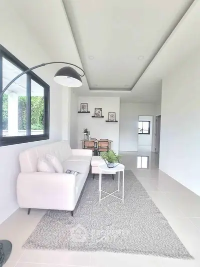 Modern living room with white sofa and stylish decor in a bright, open space.