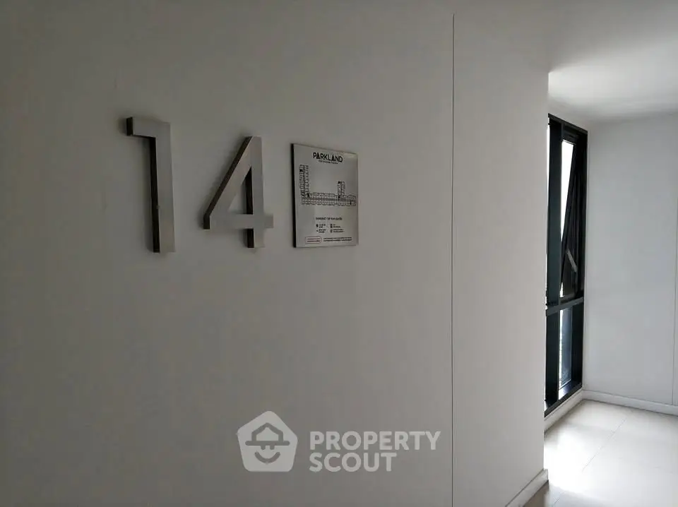 Modern apartment hallway with floor number signage and natural light.