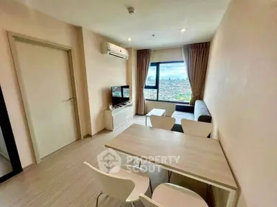 Modern living room with city view, featuring sleek furniture and natural light.
