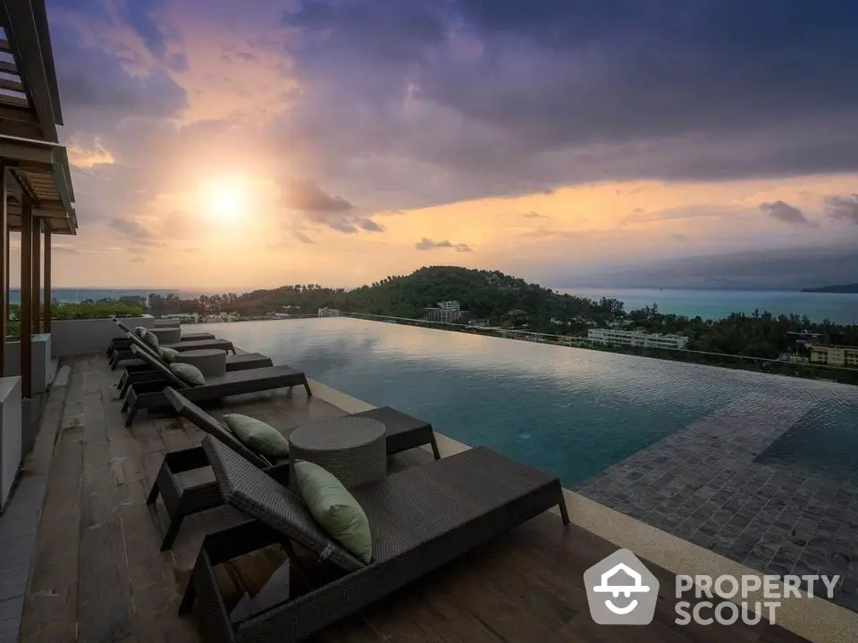 Luxurious infinity pool with stunning sunset view over the ocean and lush hills.