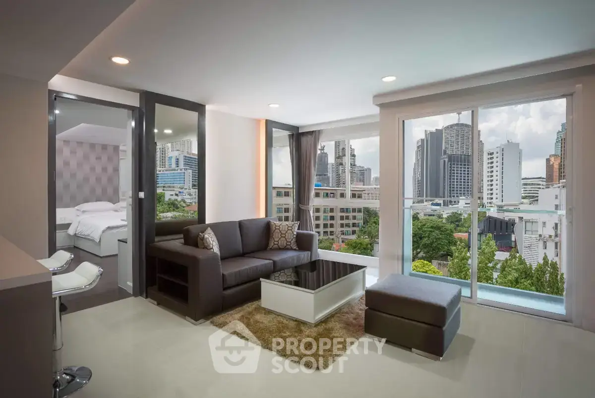 Modern living room with city view, featuring sleek furniture and large windows in a high-rise apartment.