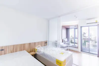 Modern bedroom with twin beds, sliding glass doors, and city view balcony.