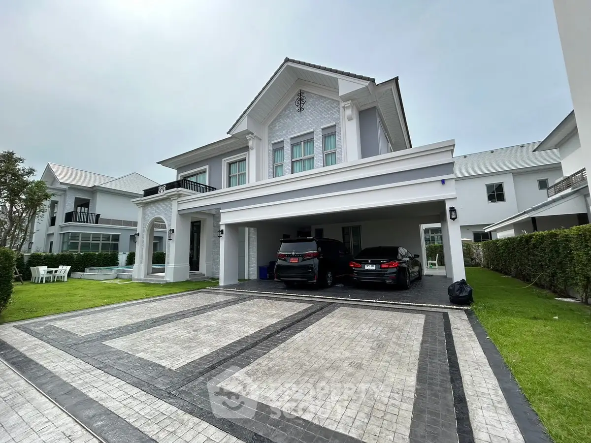Luxurious modern house with spacious driveway and elegant facade in a serene neighborhood.