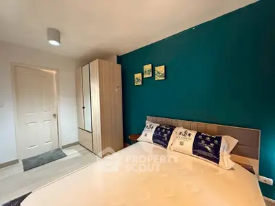 Modern bedroom with teal accent wall and stylish wardrobe