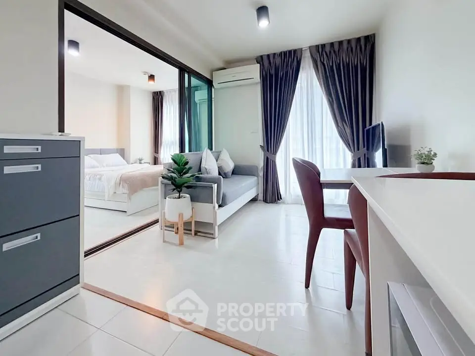 Modern open-plan living room with sleek furniture and natural light in a stylish apartment.