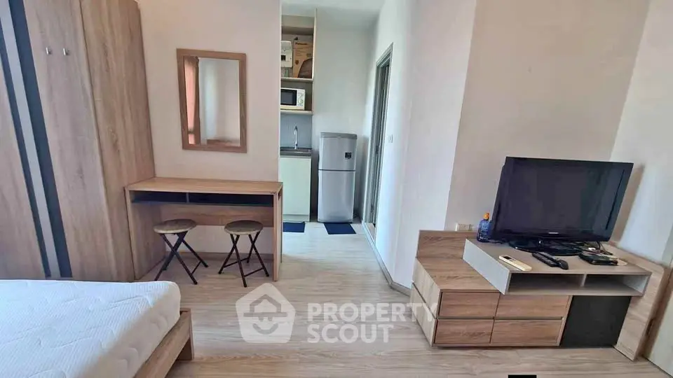 Modern studio apartment with cozy bedroom and compact kitchen area, ideal for urban living.