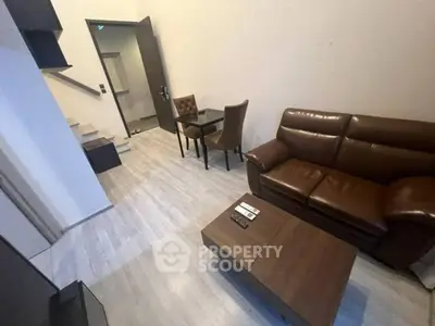 Modern living room with leather sofa and sleek wooden furniture in a cozy apartment.