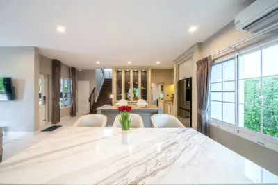 Luxurious open-plan living room with modern kitchen and elegant marble dining table.