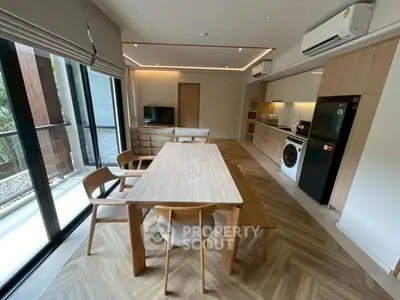 Modern open-plan kitchen and dining area with wooden accents and natural light.
