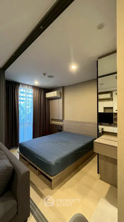 Modern bedroom with large window and stylish furnishings in a cozy apartment.