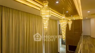 Luxurious interior with elegant chandeliers and floor-to-ceiling curtains in a modern home.
