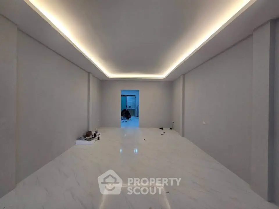 Spacious modern room with elegant lighting and marble flooring, ideal for versatile interior design.