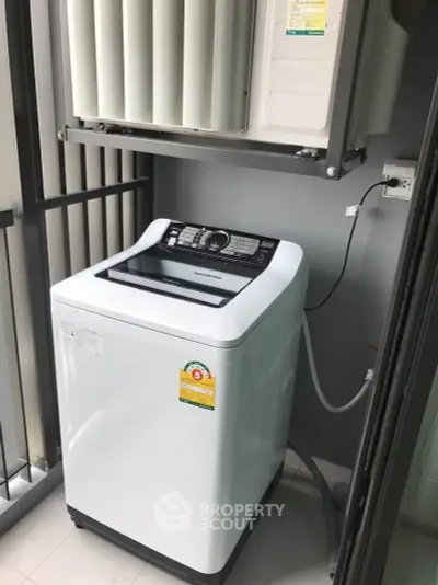 Modern washing machine on a balcony with air conditioning unit above.