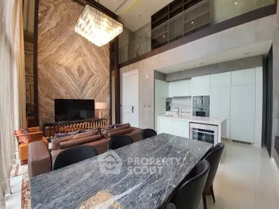 Luxurious open-concept living space with high ceilings, marble dining table, modern kitchen, and elegant chandelier, perfect for entertaining.
