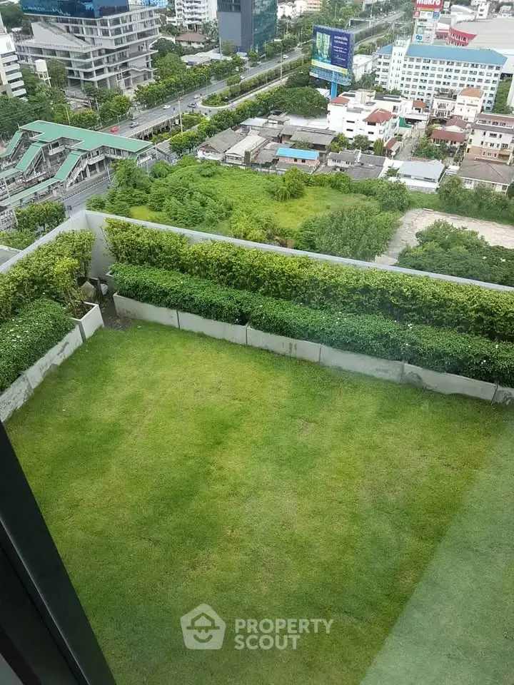 Stunning high-rise view with lush green garden and cityscape, perfect for urban living.