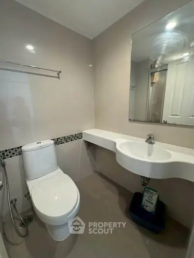 Modern bathroom with sleek fixtures and elegant design, featuring a wall-mounted sink and contemporary toilet.