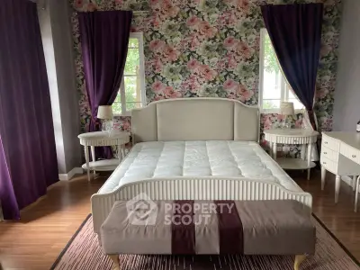 Charming bedroom with floral wallpaper and elegant furniture, featuring a cozy bed and stylish decor.