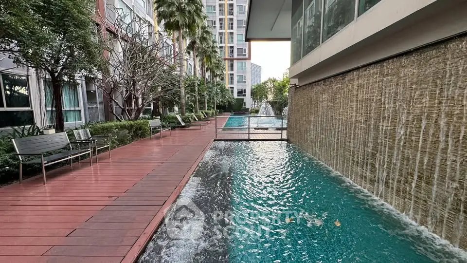 Luxurious apartment complex with serene water features and lush greenery