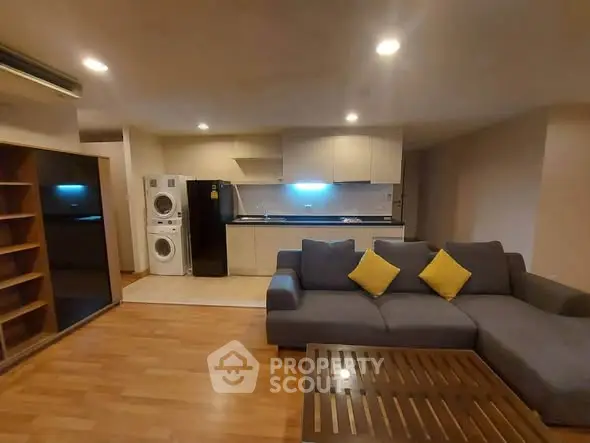 Spacious living room with modern kitchen and cozy seating area, perfect for relaxation and entertaining.