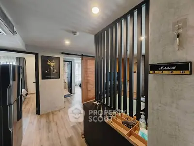 Modern apartment interior with stylish decor and open layout, featuring a sleek partition and wooden flooring.