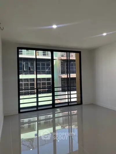 Spacious empty room with large windows and glossy tiled floor, perfect for customization.