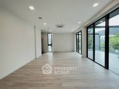 Spacious modern living room with large windows and balcony access