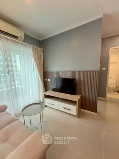 Modern living room with TV, cozy sofa, and elegant decor in a stylish apartment.
